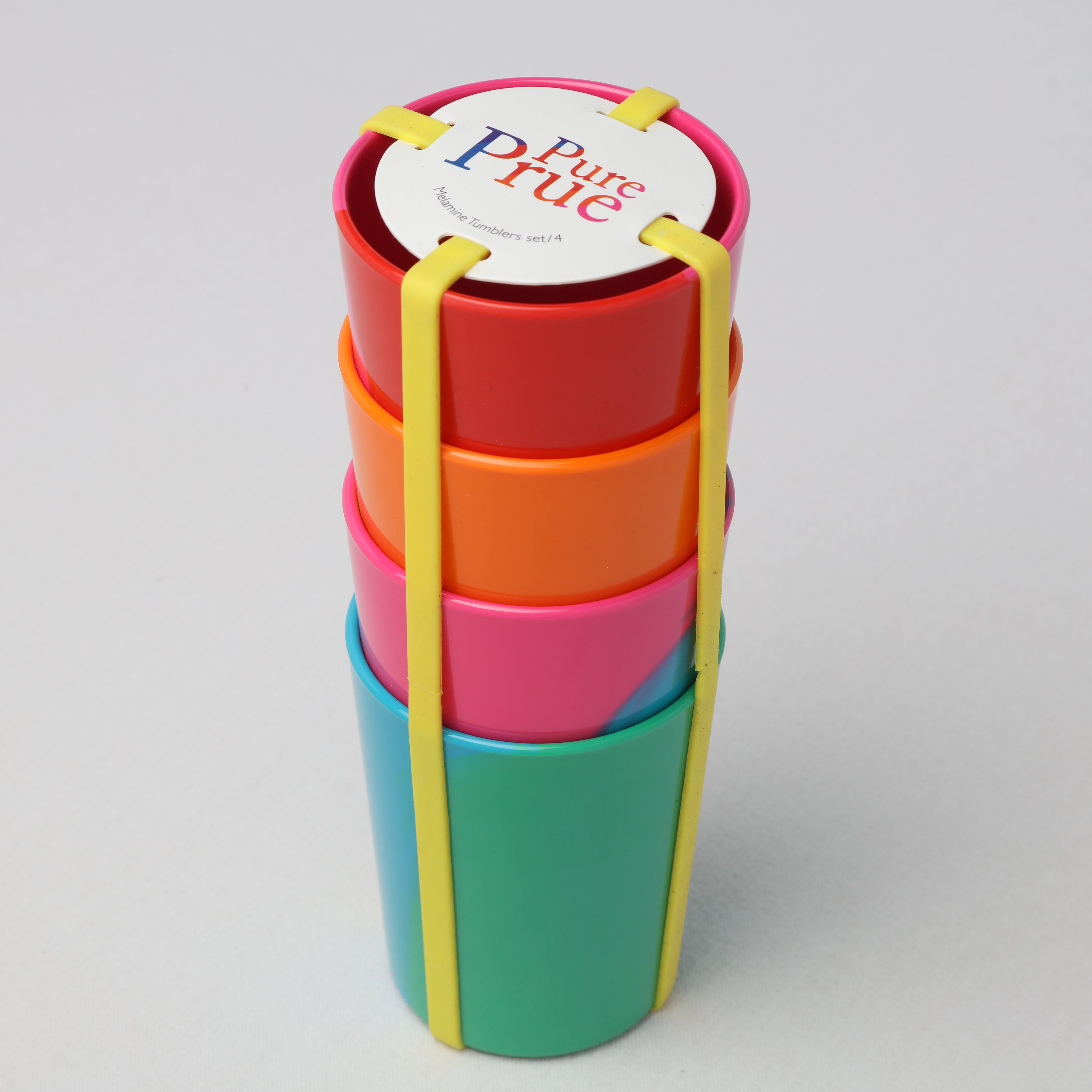 Stack of four Prue Leith colorful melamine tumblers on a grey background with packaging