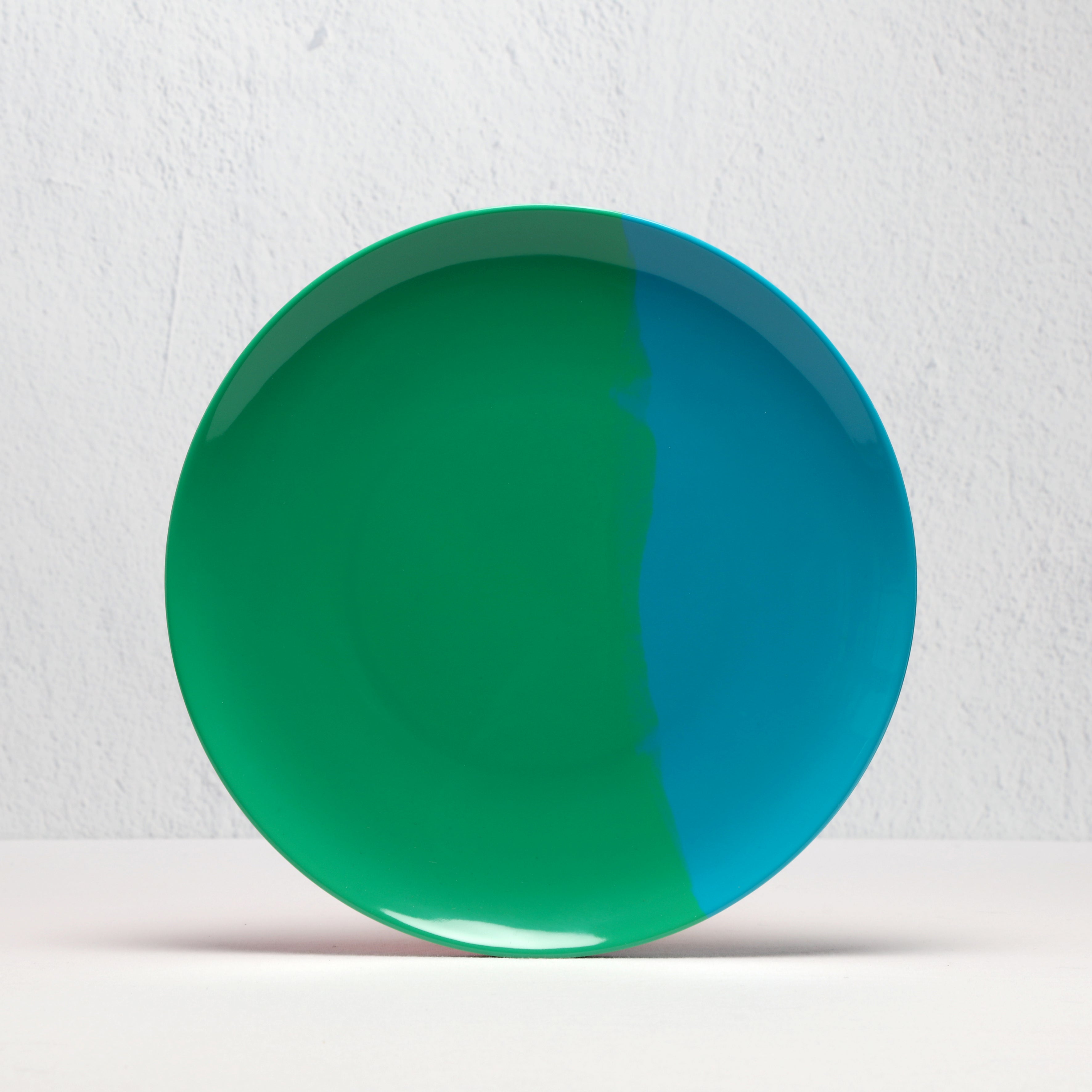 green and blue plate on a textured white background