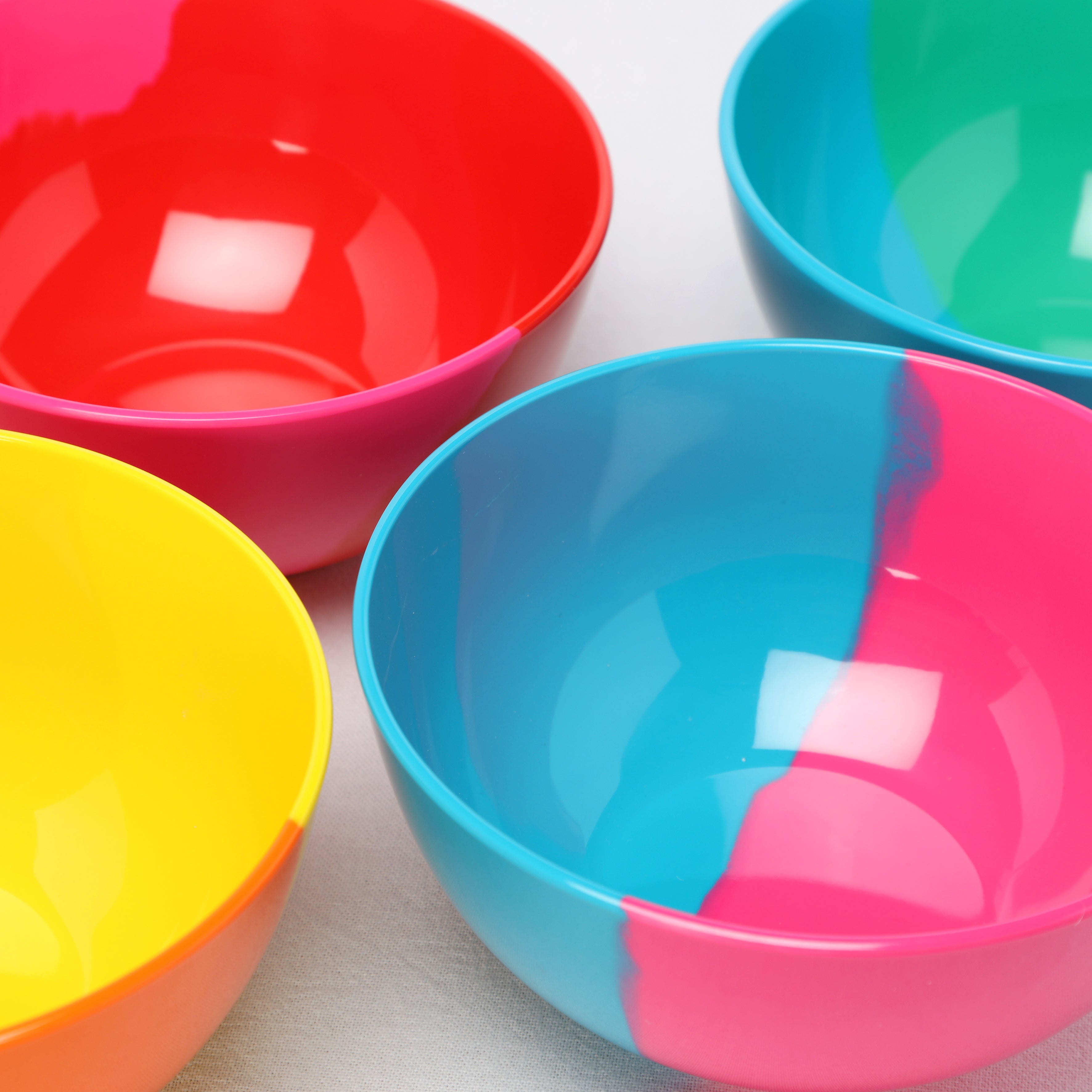 Four Prue Leith melamine colorful bowls on a light background