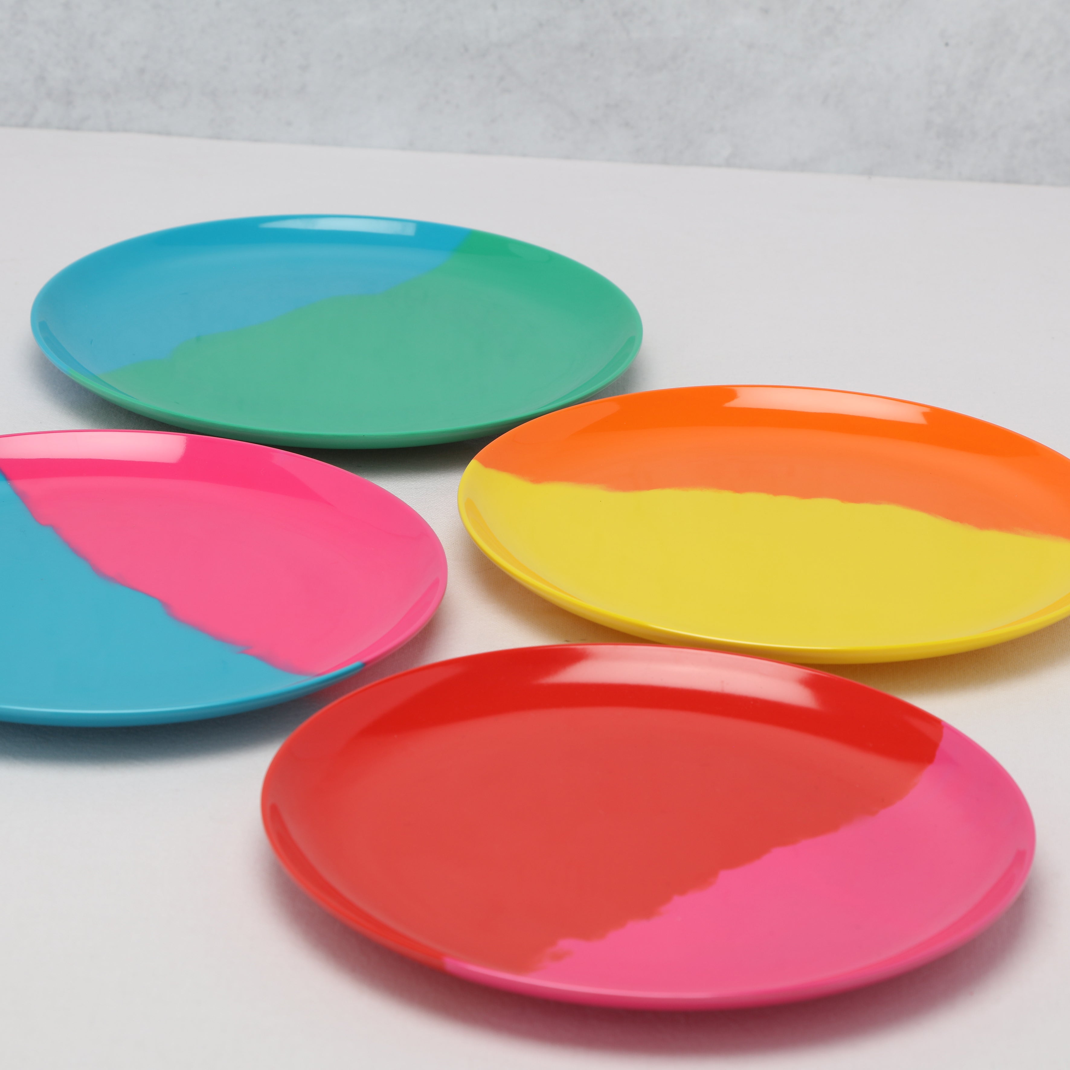 Set of colorful round plates on a white background at an angle