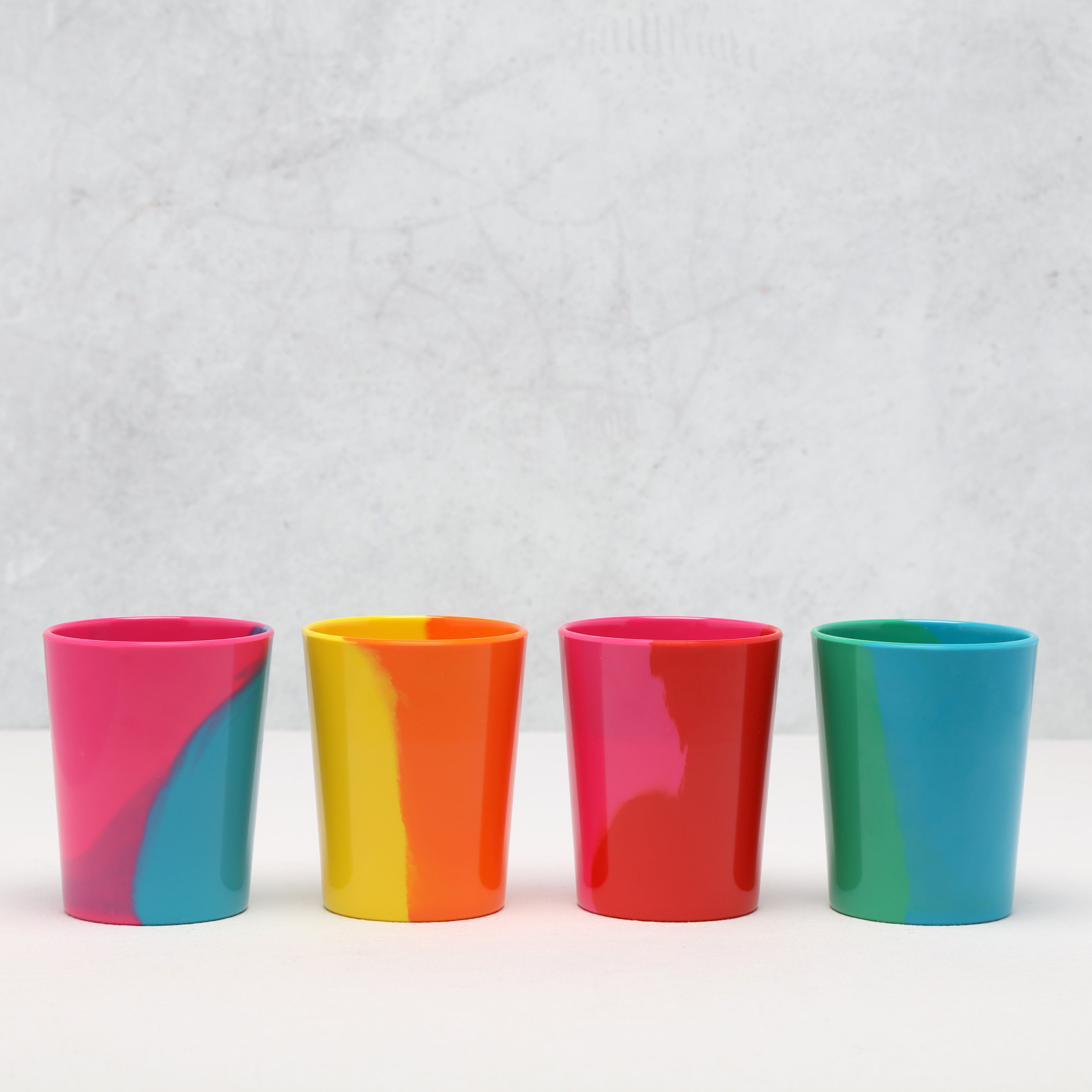Four colorful Prue Leith tumblers in a row on a light gray background