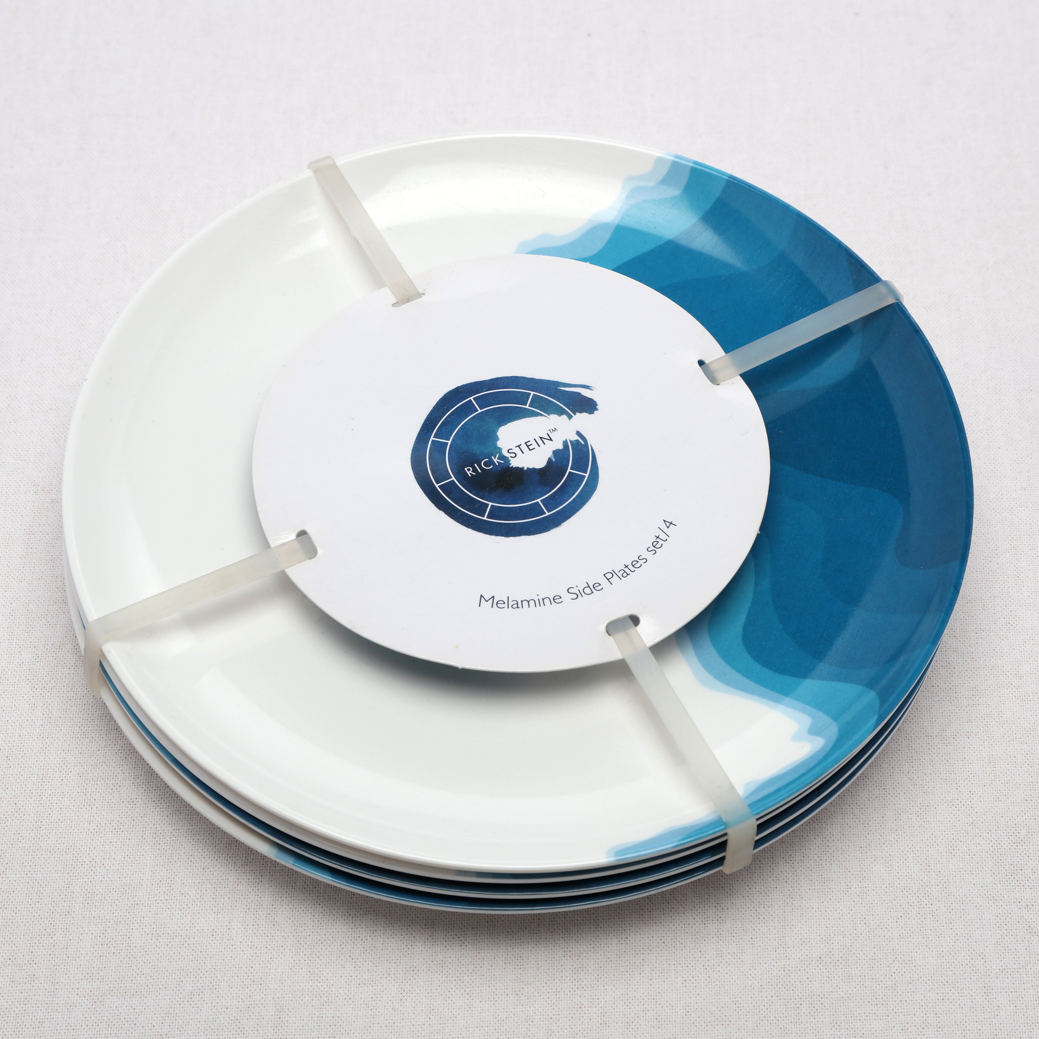 Side View of a set of four Rick Stein Melamine Dinner Plates with packaging.