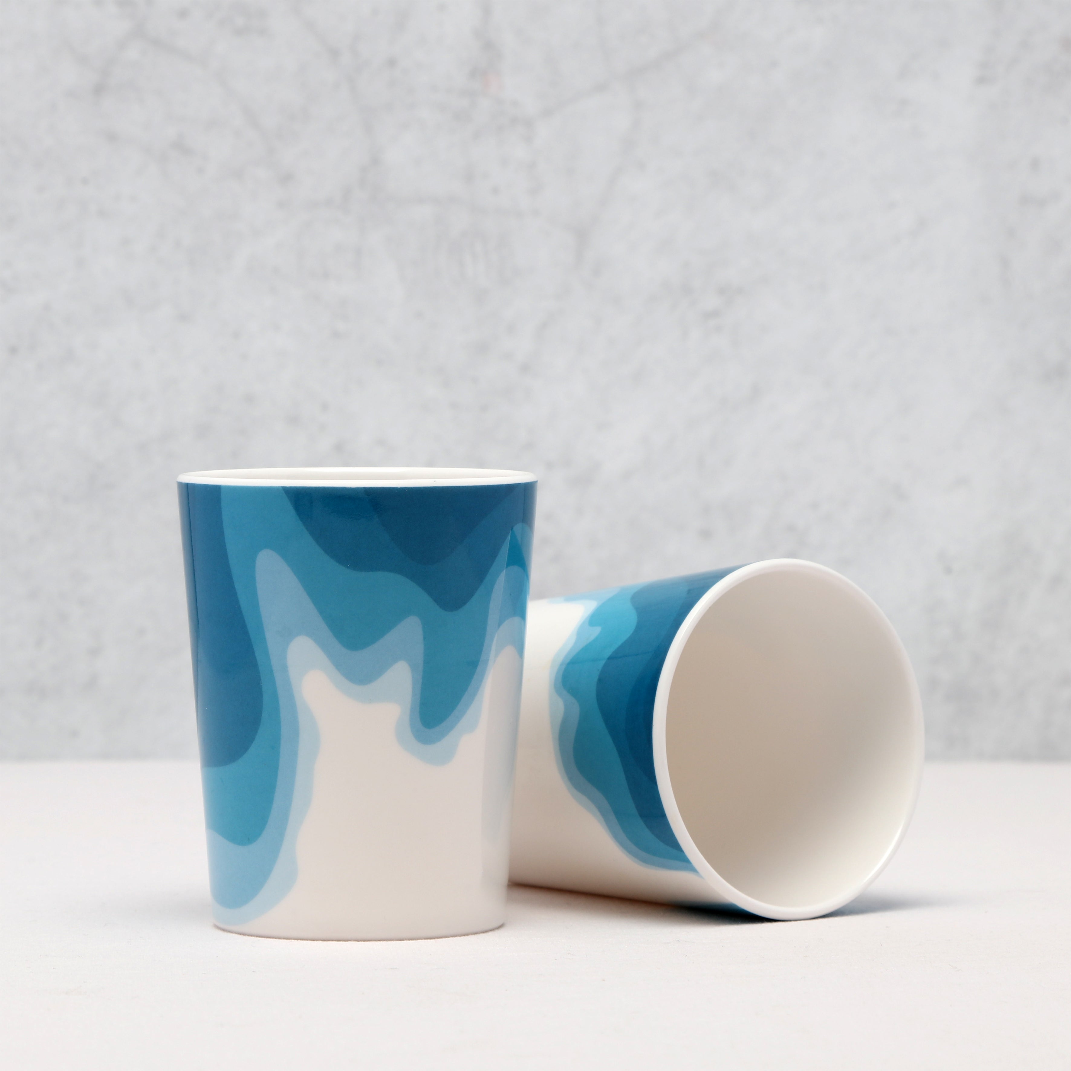 Two Rick Stein Melamine Tumblers with blue coast design, side view on a light grey background