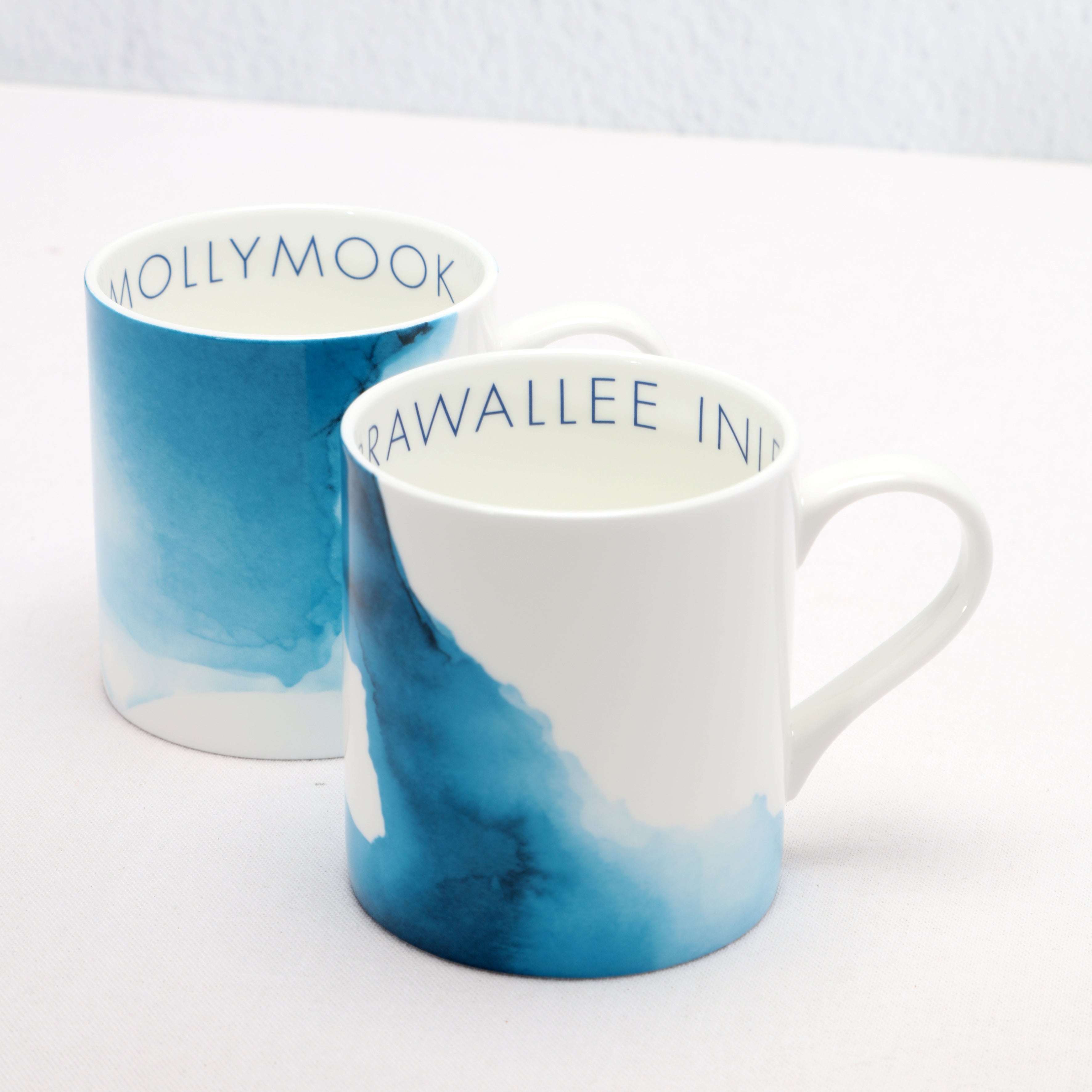 Two mugs with blue and white watercolour design on a white background