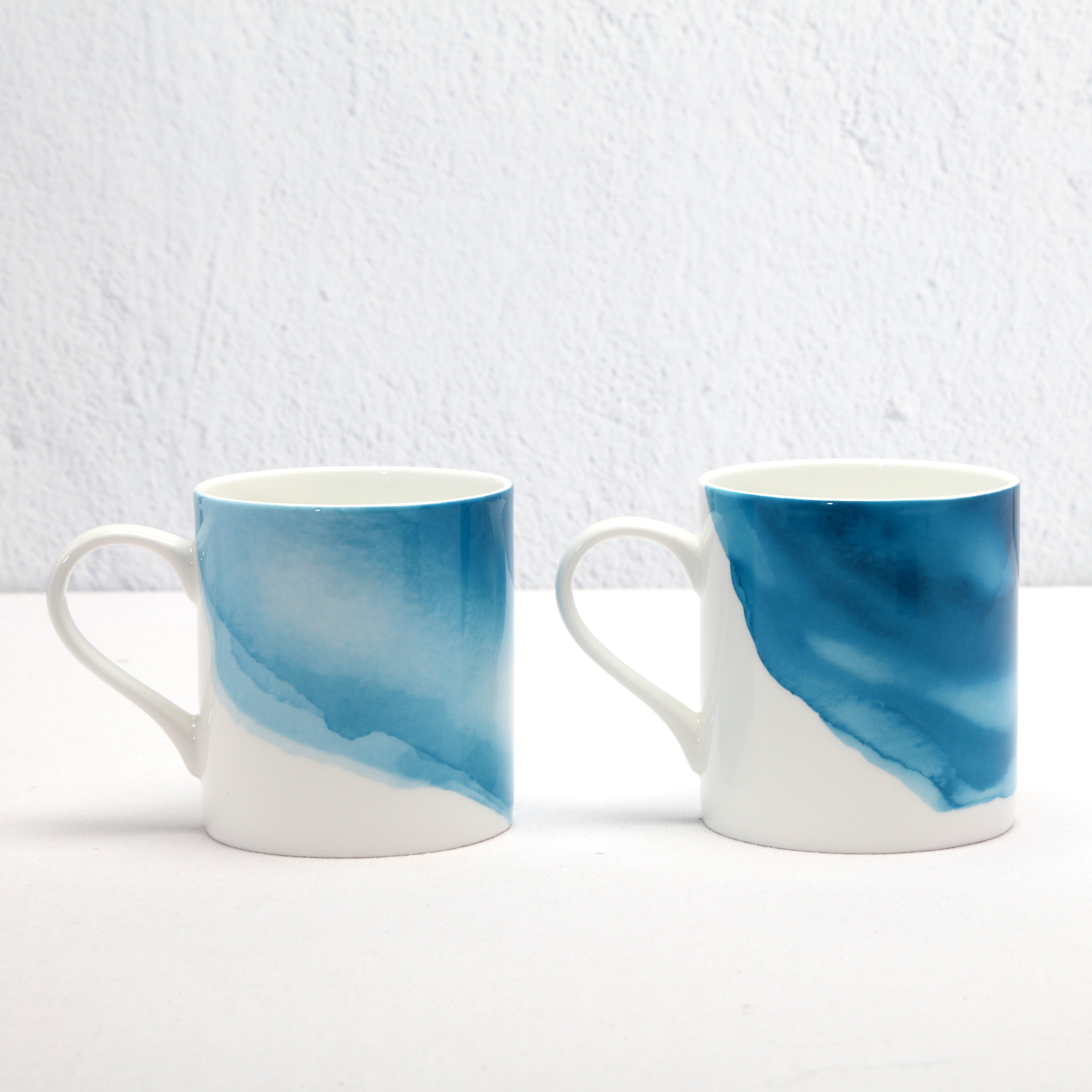 Two Bone China mugs with blue and white watercolour design on a white background