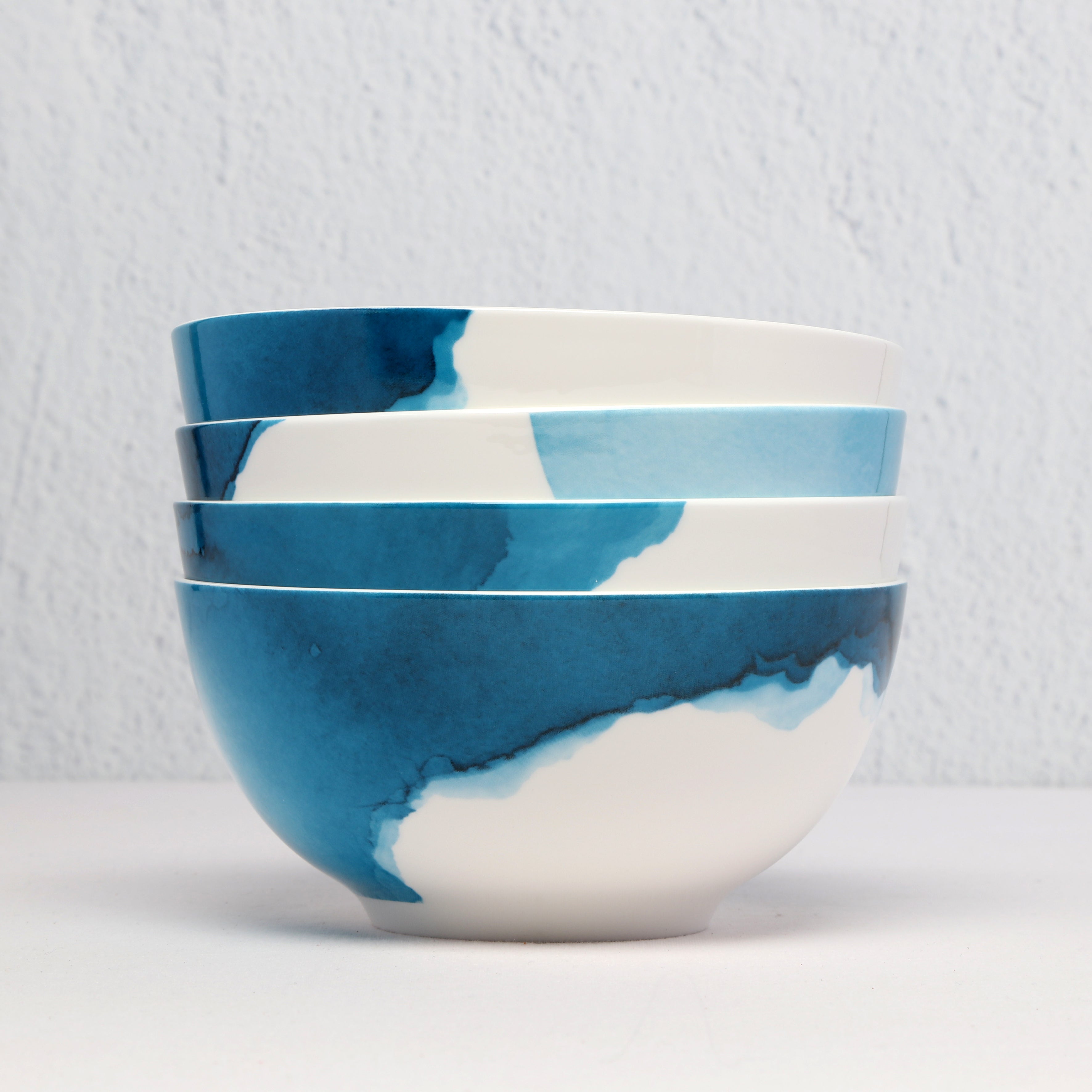 Set of four Bone China blue and white bowls on a light gray background