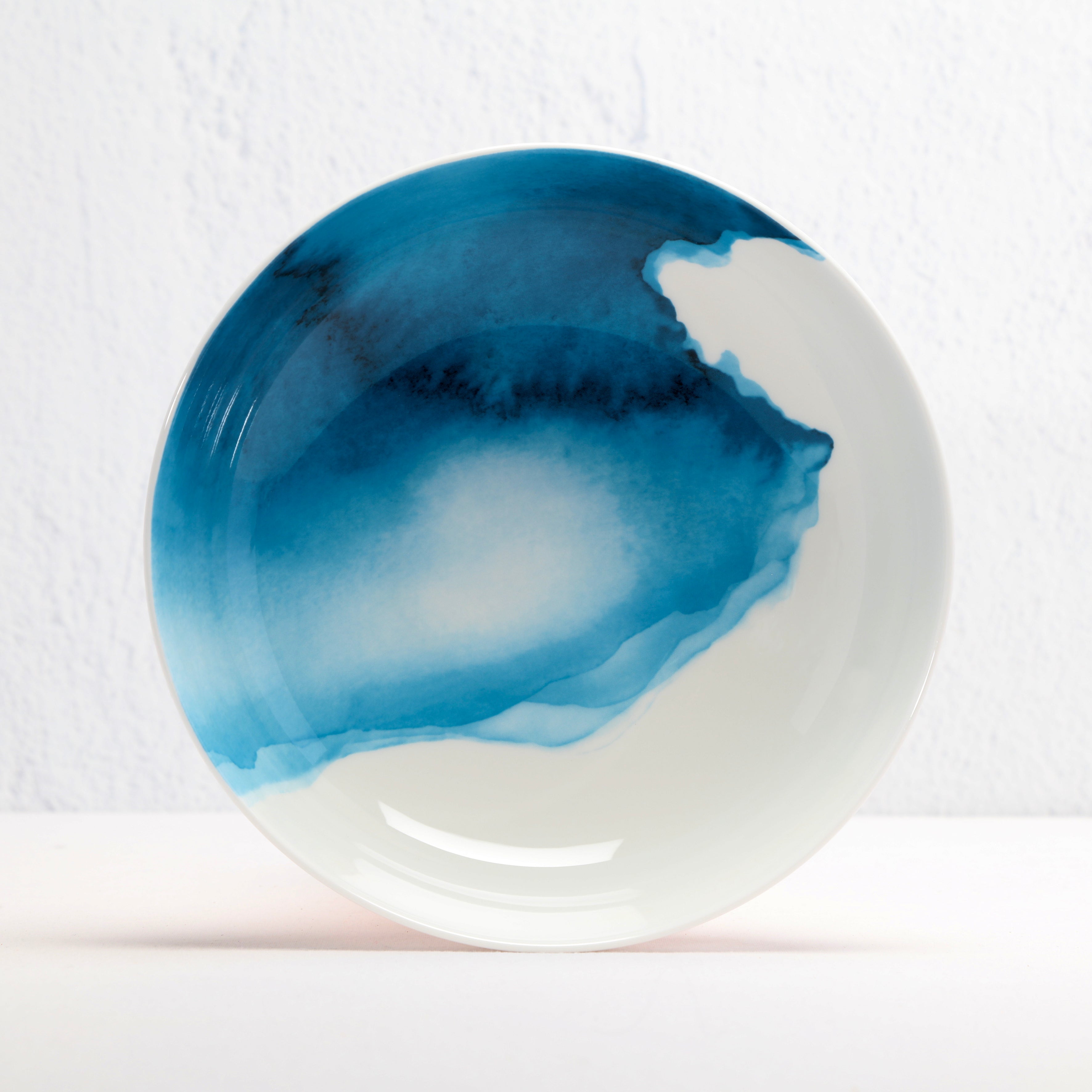 Round ceramic supper bowl with blue watercolour design on a white background