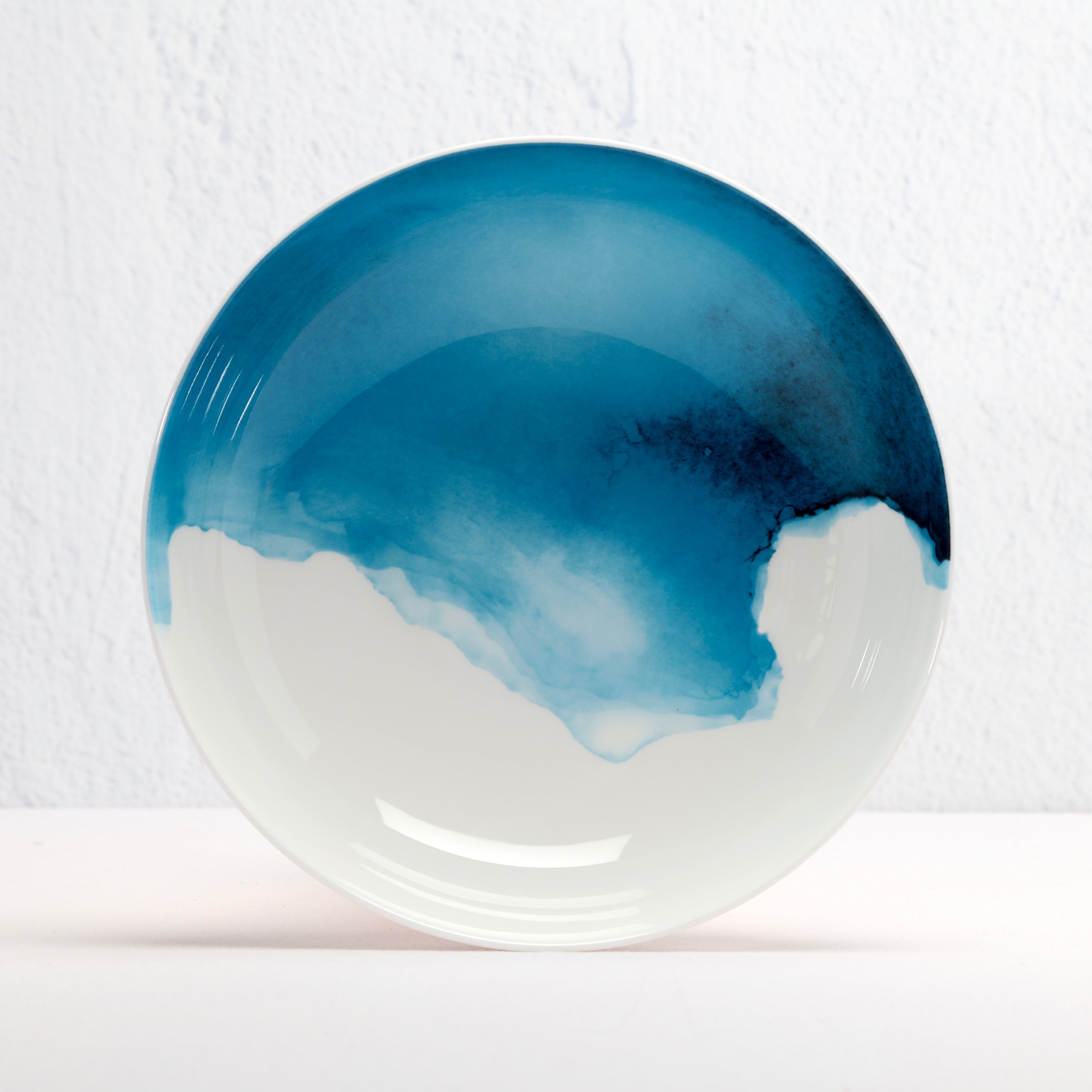 Ceramic Bone China bowl with blue and white abstract design on a textured white background