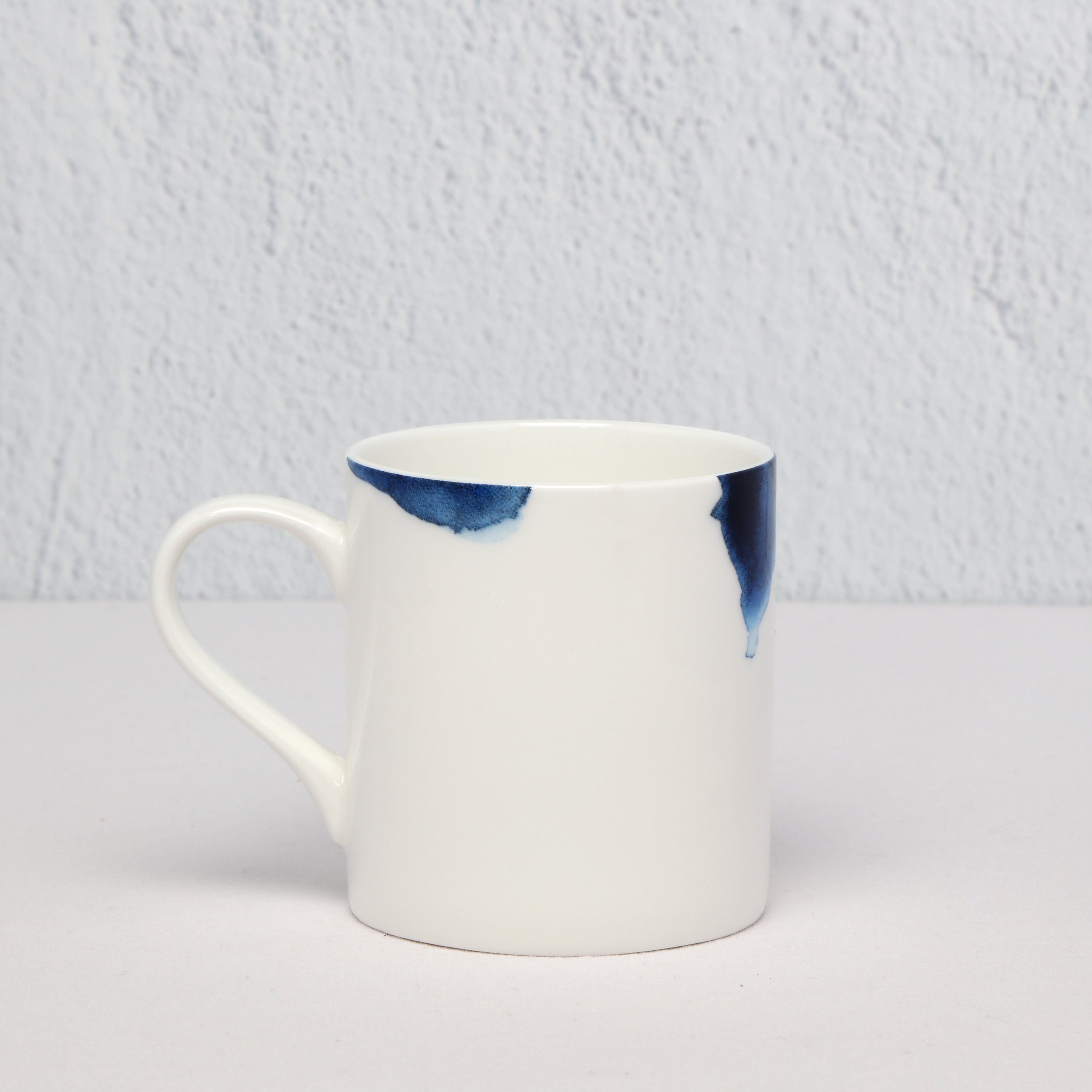 White mug with blue accent on a light gray background