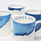 Set of four bone china mugs with blue and white design and text on a white background